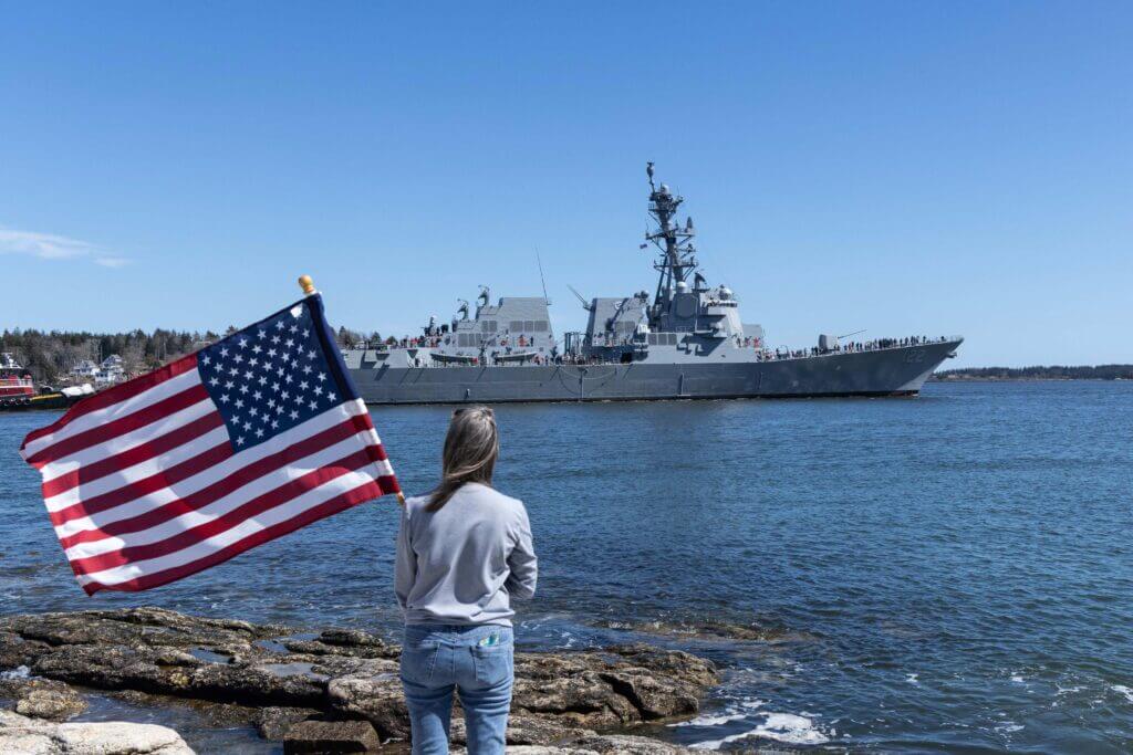 Onlooker waves big American flag as John Basilone (DDG 122) sails past