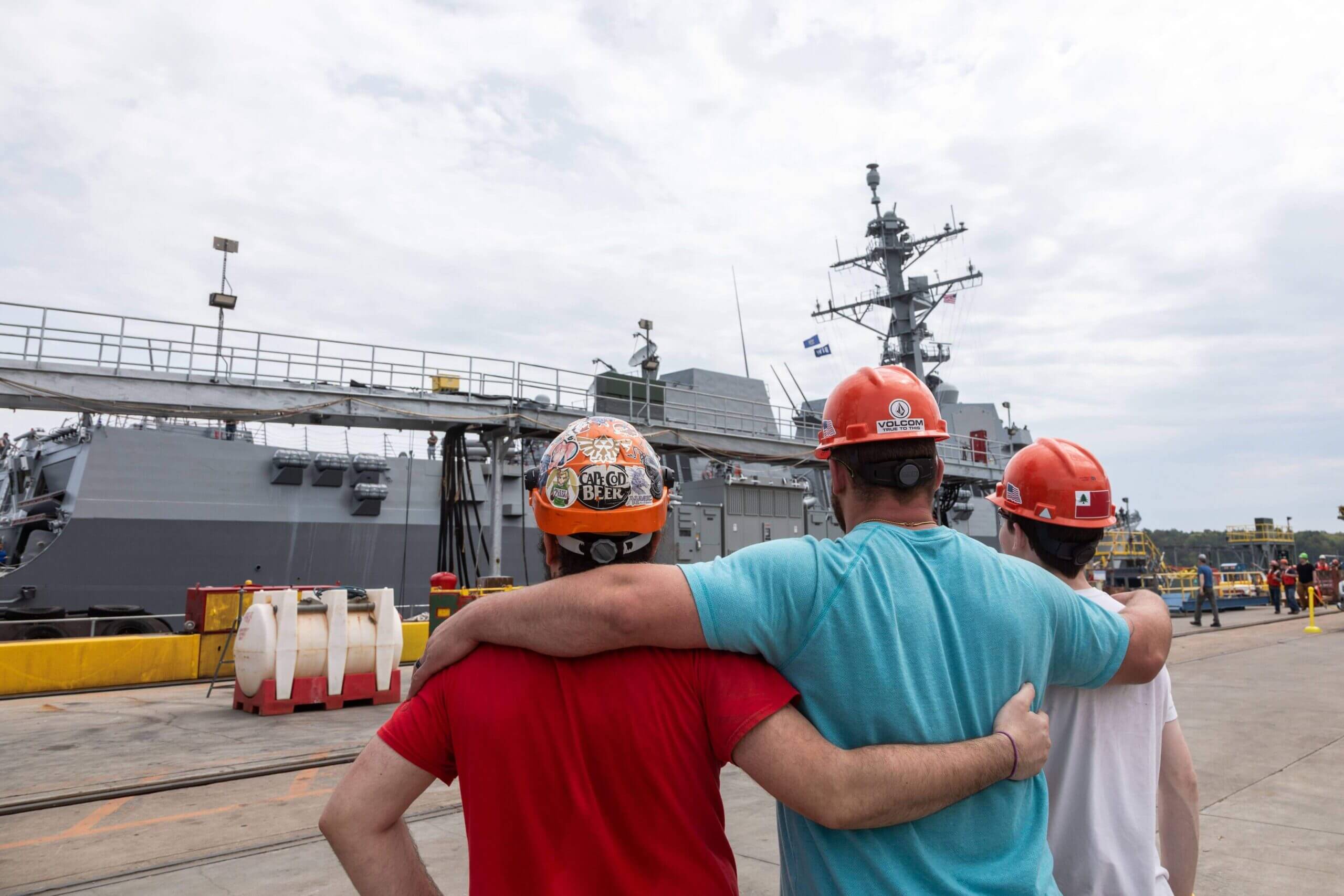 Three riggers look on at destroyer during acceptance trials