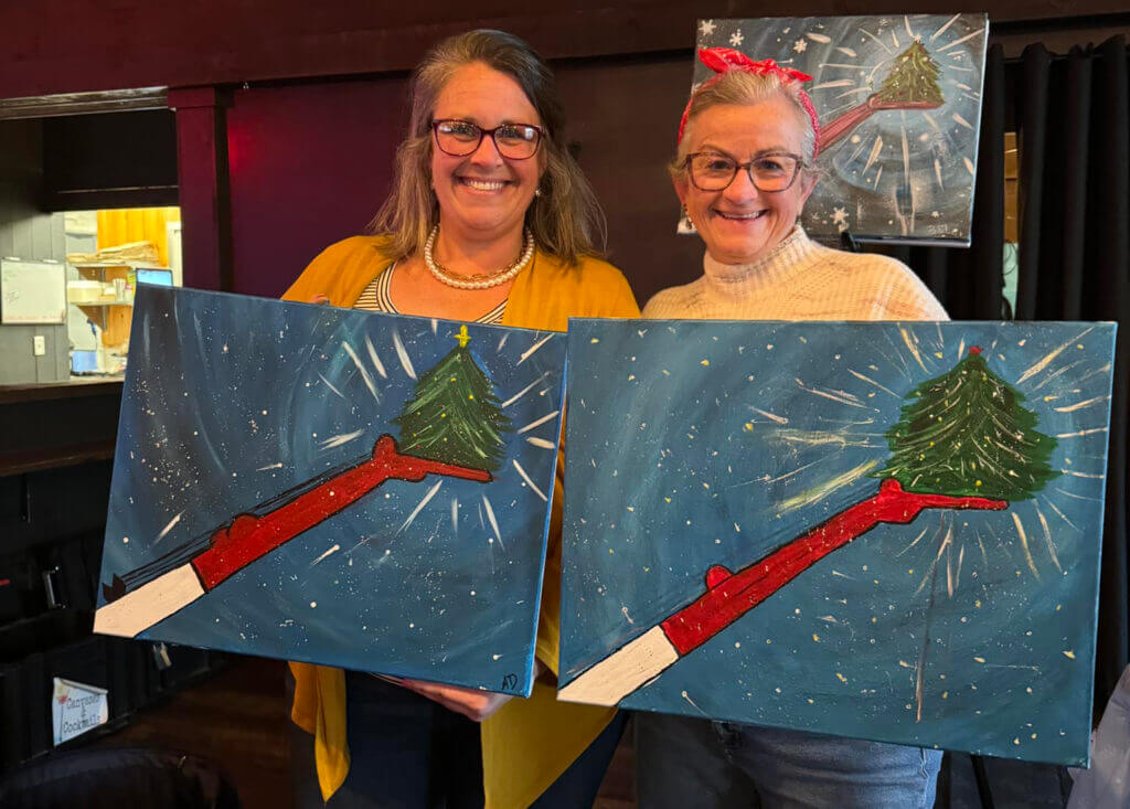 Two BIW employees show off their painting during a BIW Paint Party
